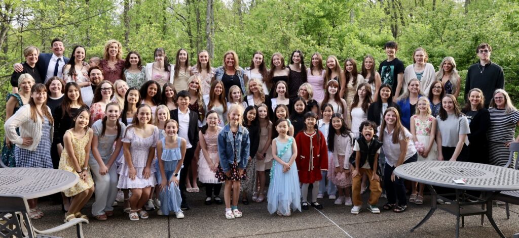 Group photo of adults and children standing outside